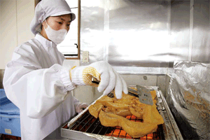 厚さ3センチはあろうかという特性厚揚げを丁寧に焼き上げていく　写真