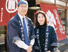 明治8年に創業した老舗漬物店ののれんを守る四十萬谷正久社長と妻の直美さん　写真