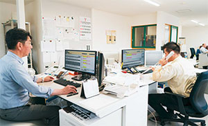 野々市運輸機工では二人の社員が配車業務に専従。システムを利用して業務を行っている様子の写真。