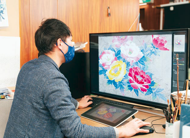 スキャナーで画像化した図案データをディスプレイ表示し、色や配置などを検討している人の写真