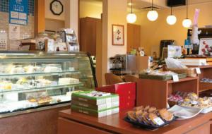 松月堂の店舗の内観写真。手づくりの和洋菓子が並び、奥にはカフェスペースもある。