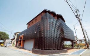 外装材に有孔折板が使われている建物の写真。
