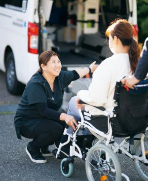 ケアタクシー利用者に笑顔で対応する坂田社長の写真