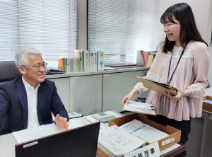 職員に決裁書類を回すH.Hさんの写真