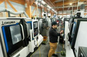 高松工場で働く従業員の写真。津幡工場と合わ せ、約200台の工作機械が並ぶ。