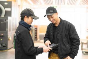 従業員にアプリの使い方をアド バイスする岡田専務の写真。