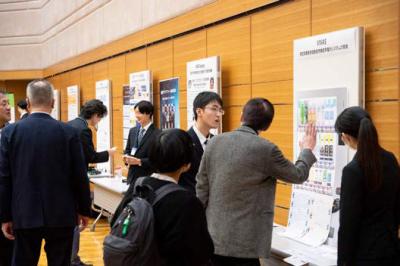 展示パネルの前で話をする登壇者と梨状者の写真。活発に交流が行われた。