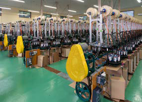 工場内にずらりと並ぶ製紐機の写真。