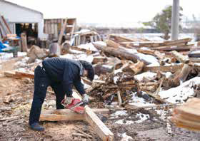廃材を切り出し、燃料にする様子の写真